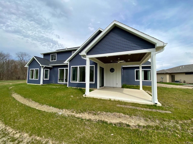 rear view of property featuring a yard, ceiling fan, and a patio