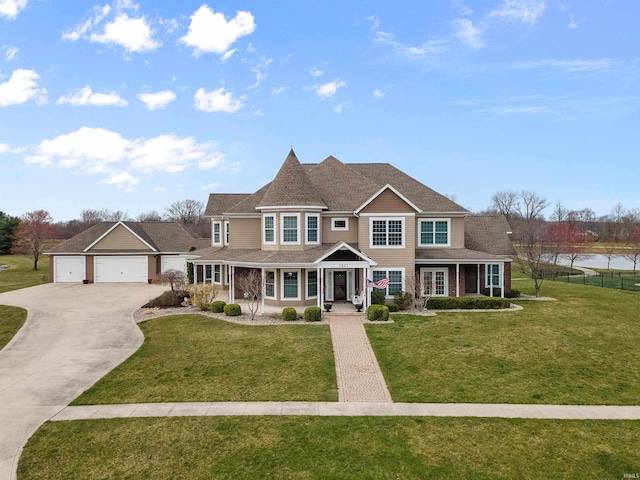 view of front of property with a porch, a front yard, and a garage