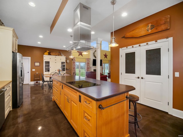 kitchen with pendant lighting, a kitchen breakfast bar, black electric cooktop, stainless steel fridge, and island exhaust hood