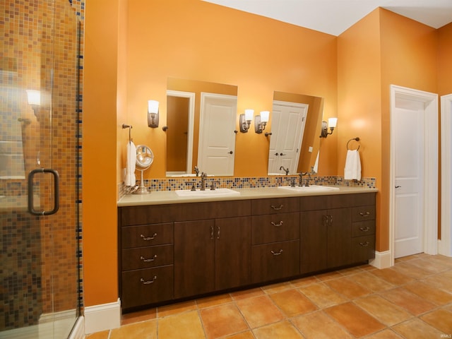 bathroom featuring backsplash, a shower with door, tile flooring, and dual vanity