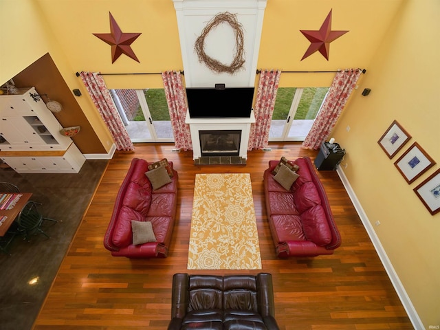 living room featuring dark wood-type flooring and a high ceiling