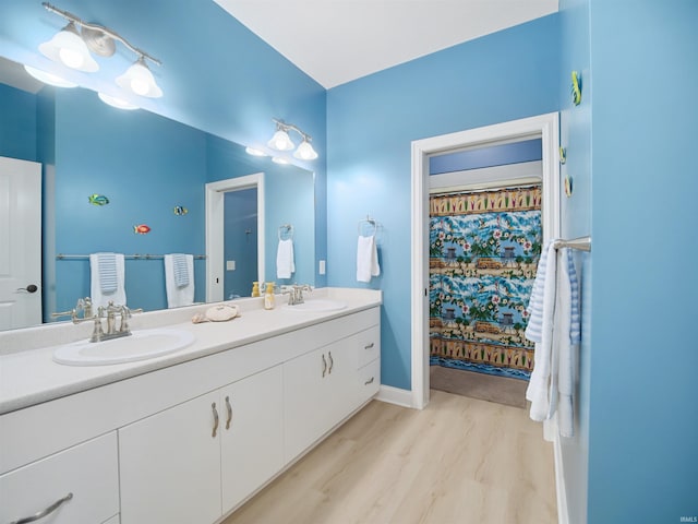 bathroom with double sink vanity and wood-type flooring