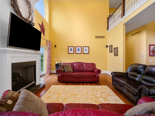 living room featuring wood-type flooring and a towering ceiling