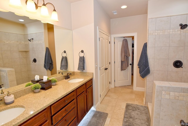 bathroom with dual bowl vanity, tile flooring, and tiled shower