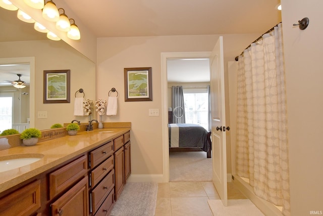 bathroom with vanity with extensive cabinet space, ceiling fan, dual sinks, and tile flooring