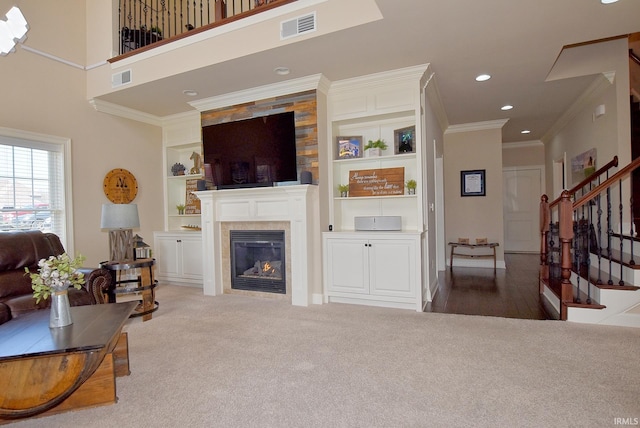 living room featuring ornamental molding, built in shelves, dark hardwood / wood-style flooring, and a fireplace