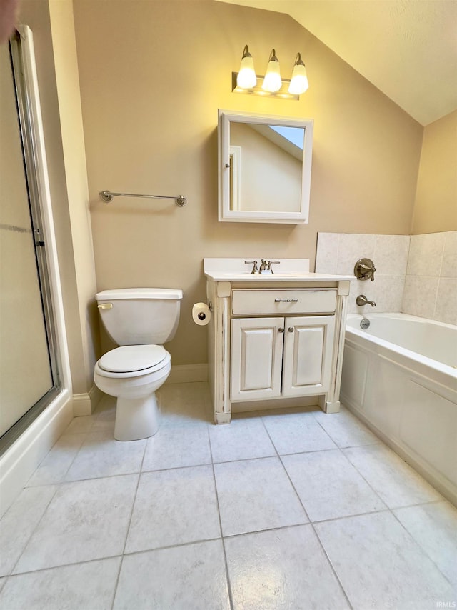 bathroom featuring tile floors, vaulted ceiling, toilet, vanity, and a tub