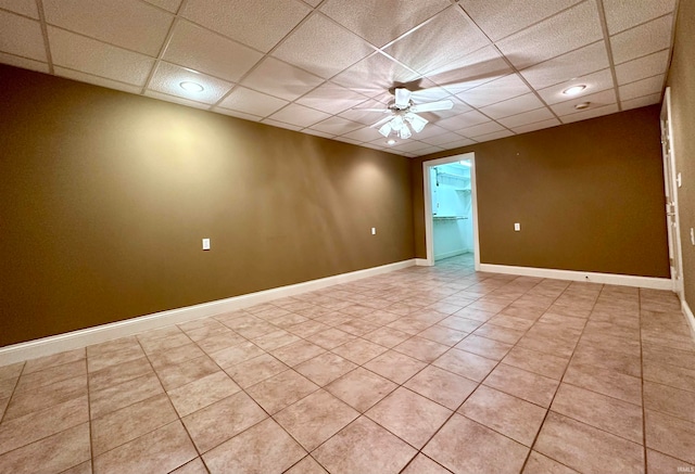 tiled spare room with ceiling fan and a drop ceiling