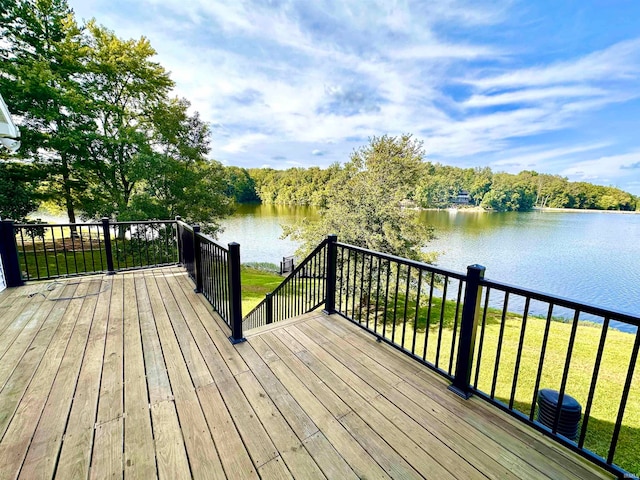 deck with central AC unit, a water view, and a yard