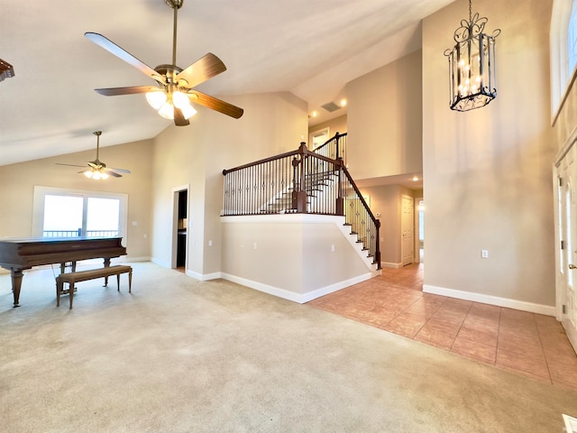 tiled living room featuring high vaulted ceiling and ceiling fan with notable chandelier