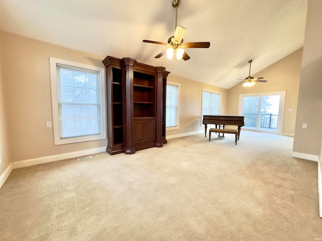 interior space featuring ceiling fan, lofted ceiling, and light colored carpet