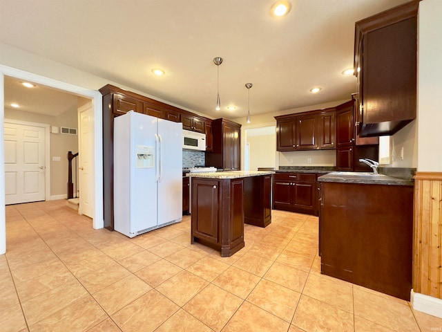 kitchen featuring light tile floors, hanging light fixtures, a center island, and white appliances