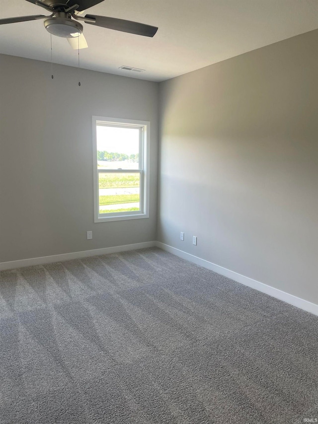 empty room featuring carpet flooring, baseboards, visible vents, and ceiling fan