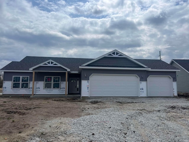 view of front of home with an attached garage, driveway, and roof with shingles