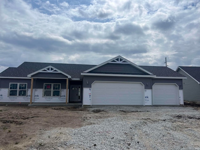 view of front of property featuring a garage, roof with shingles, and driveway