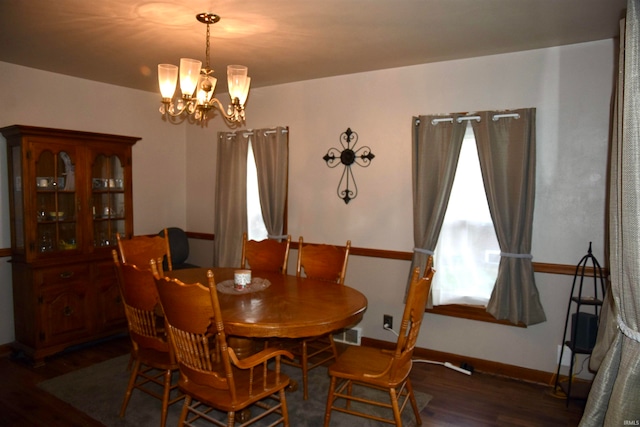 dining space featuring dark hardwood / wood-style floors and a notable chandelier