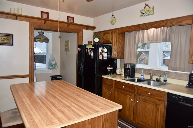 kitchen featuring black appliances, a center island, and sink