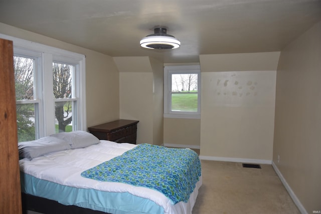 carpeted bedroom featuring multiple windows and vaulted ceiling