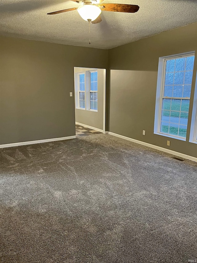 carpeted spare room with ceiling fan and a textured ceiling