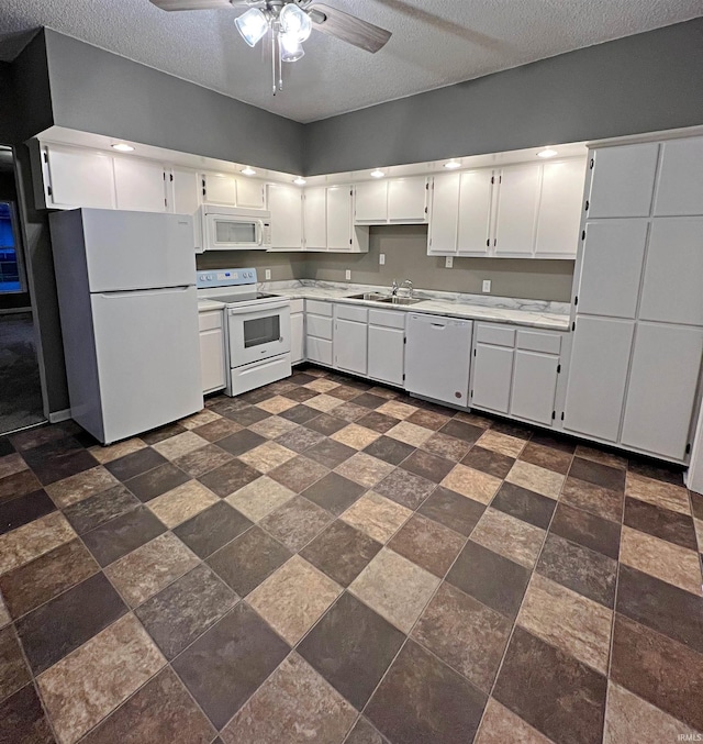 kitchen featuring dark tile flooring, white cabinetry, white appliances, and ceiling fan