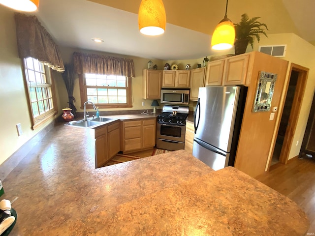 kitchen featuring light brown cabinets, stainless steel appliances, hardwood / wood-style floors, hanging light fixtures, and sink