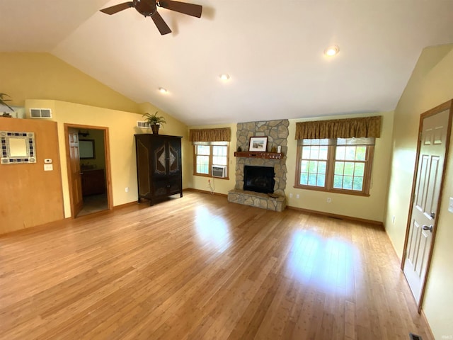 unfurnished living room featuring a healthy amount of sunlight, ceiling fan, vaulted ceiling, and light hardwood / wood-style flooring