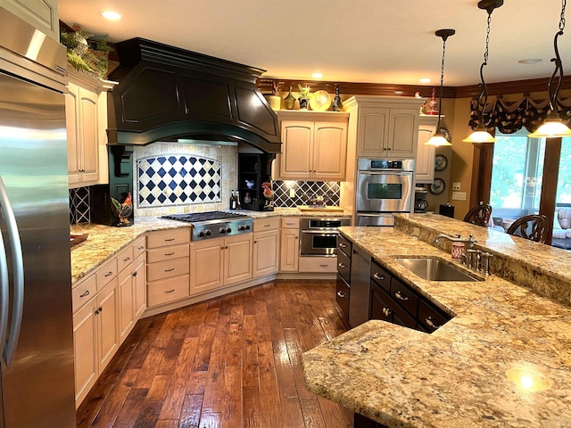 kitchen with stainless steel appliances, decorative light fixtures, dark wood-type flooring, backsplash, and sink