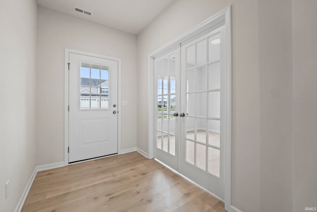 doorway to outside featuring french doors, light hardwood / wood-style flooring, and a healthy amount of sunlight