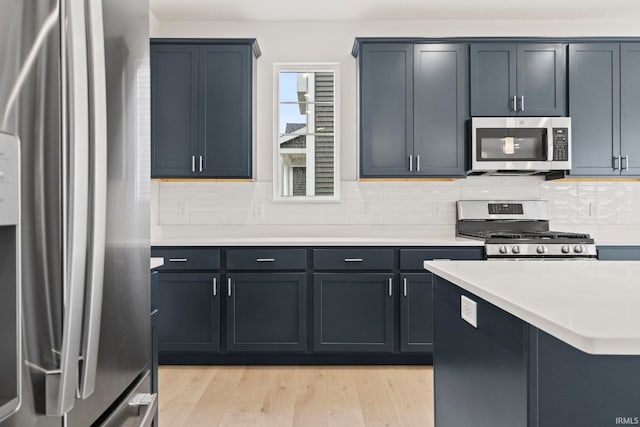 kitchen featuring light hardwood / wood-style flooring, appliances with stainless steel finishes, and tasteful backsplash