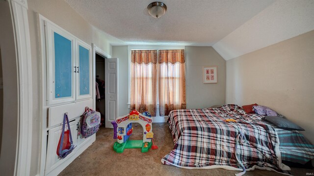 bedroom featuring a textured ceiling, dark colored carpet, and vaulted ceiling