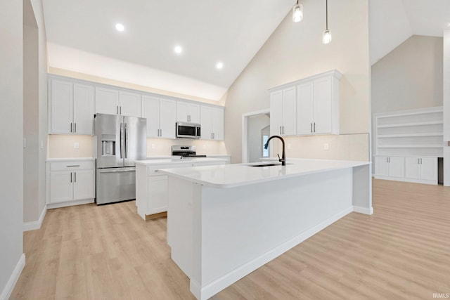 kitchen with white cabinetry, sink, high vaulted ceiling, light hardwood / wood-style floors, and appliances with stainless steel finishes