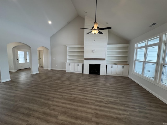 unfurnished living room featuring dark hardwood / wood-style floors, high vaulted ceiling, and plenty of natural light