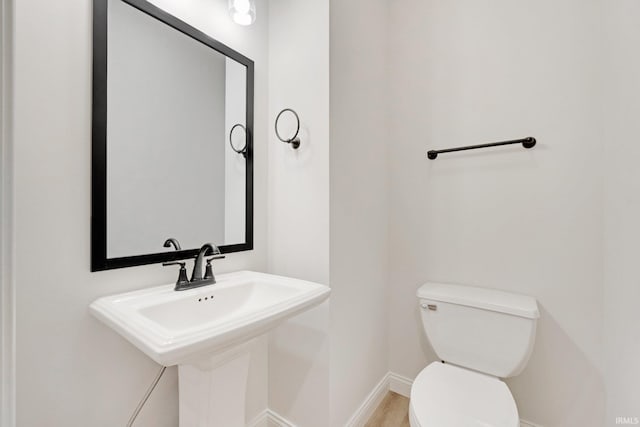 bathroom featuring hardwood / wood-style flooring, toilet, and sink