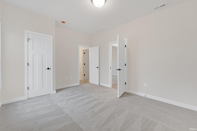 unfurnished bedroom featuring light carpet