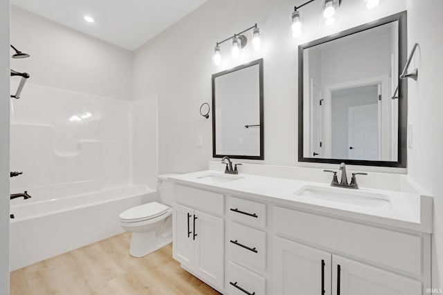 full bathroom with hardwood / wood-style floors, vanity, toilet, and shower / bath combination