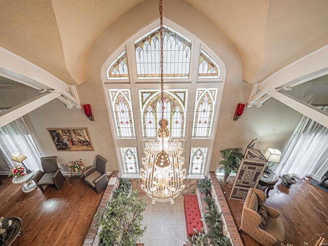 foyer with a wealth of natural light, high vaulted ceiling, and a chandelier