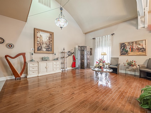 miscellaneous room featuring high vaulted ceiling, a chandelier, and hardwood / wood-style flooring