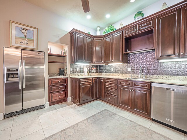 kitchen featuring tasteful backsplash, stainless steel appliances, light stone counters, and light tile flooring