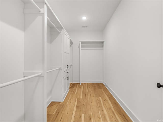 walk in closet with light hardwood / wood-style flooring