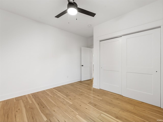 unfurnished bedroom with ceiling fan, hardwood / wood-style flooring, and a closet