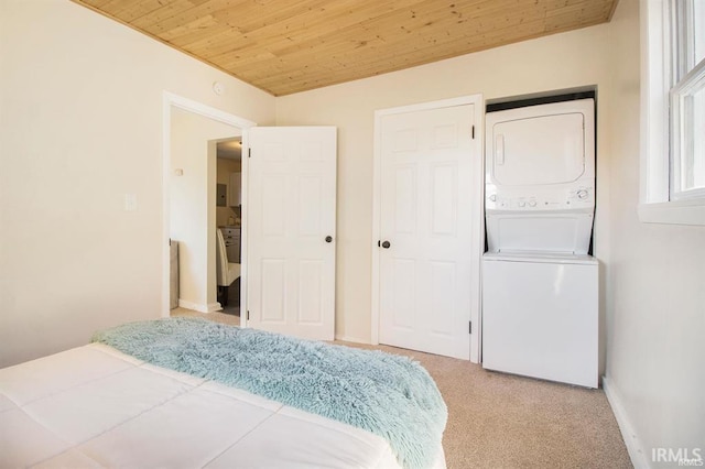 carpeted bedroom with stacked washer and clothes dryer and wooden ceiling