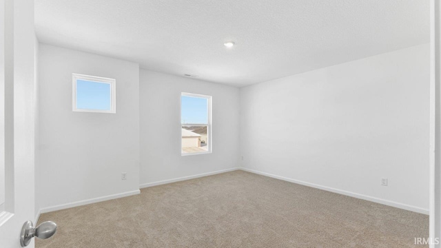 carpeted spare room with a textured ceiling