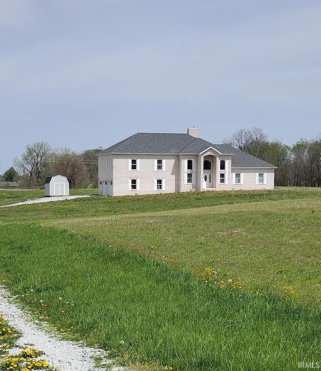 view of front facade with a front yard and a storage unit