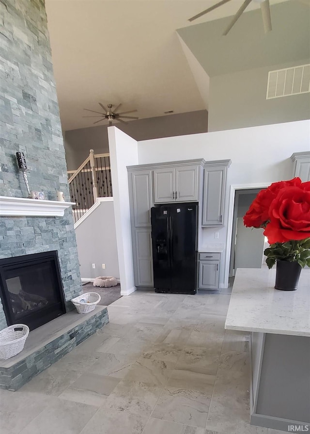 interior space with a towering ceiling and a stone fireplace