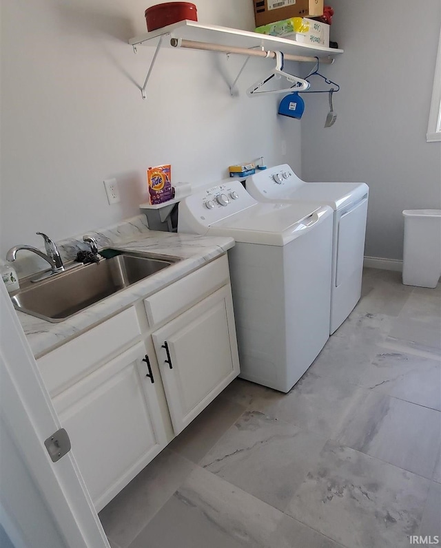 clothes washing area featuring cabinets, washing machine and dryer, and sink