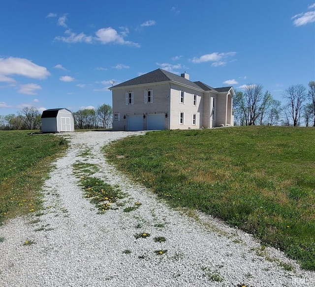 view of property exterior featuring a shed, a garage, and a lawn