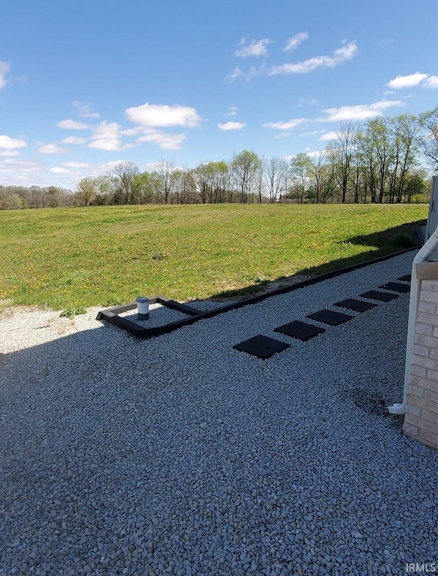 view of parking / parking lot with a rural view and a yard