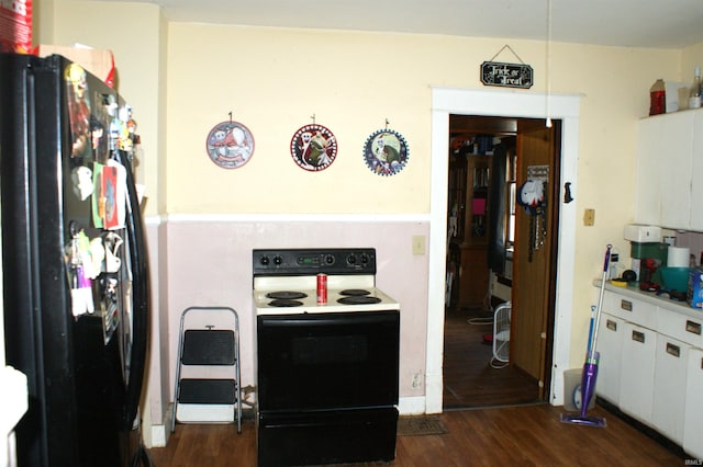 kitchen featuring white electric stove, black refrigerator, dark hardwood / wood-style flooring, and white cabinets