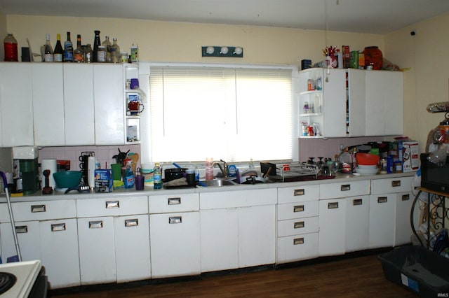 kitchen featuring backsplash, stove, white cabinets, sink, and dark hardwood / wood-style flooring