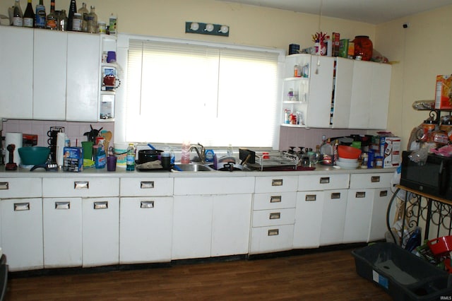 kitchen with backsplash, dark hardwood / wood-style flooring, white cabinets, and sink